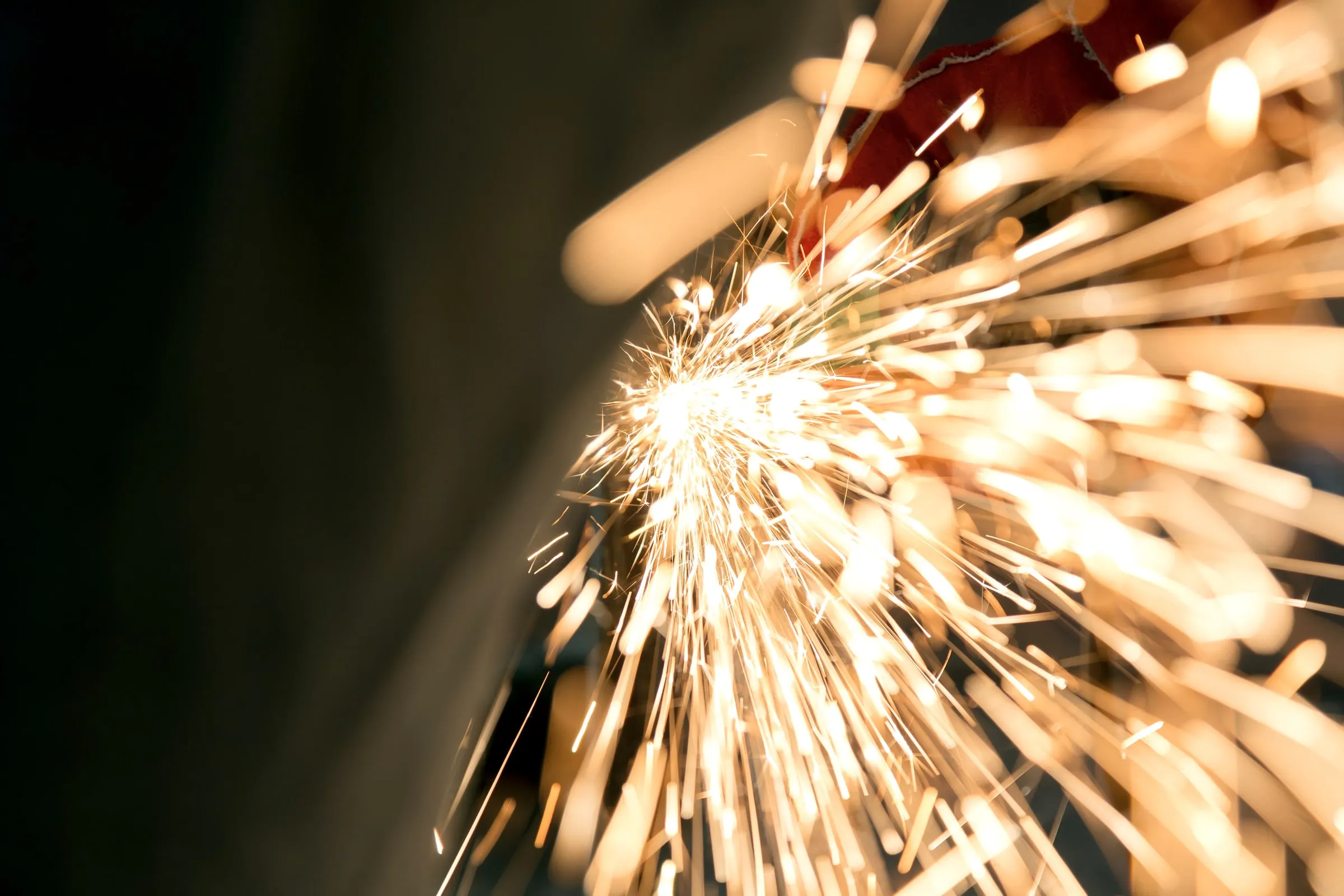 Close-up of a metal rod being cut with bright sparks flying