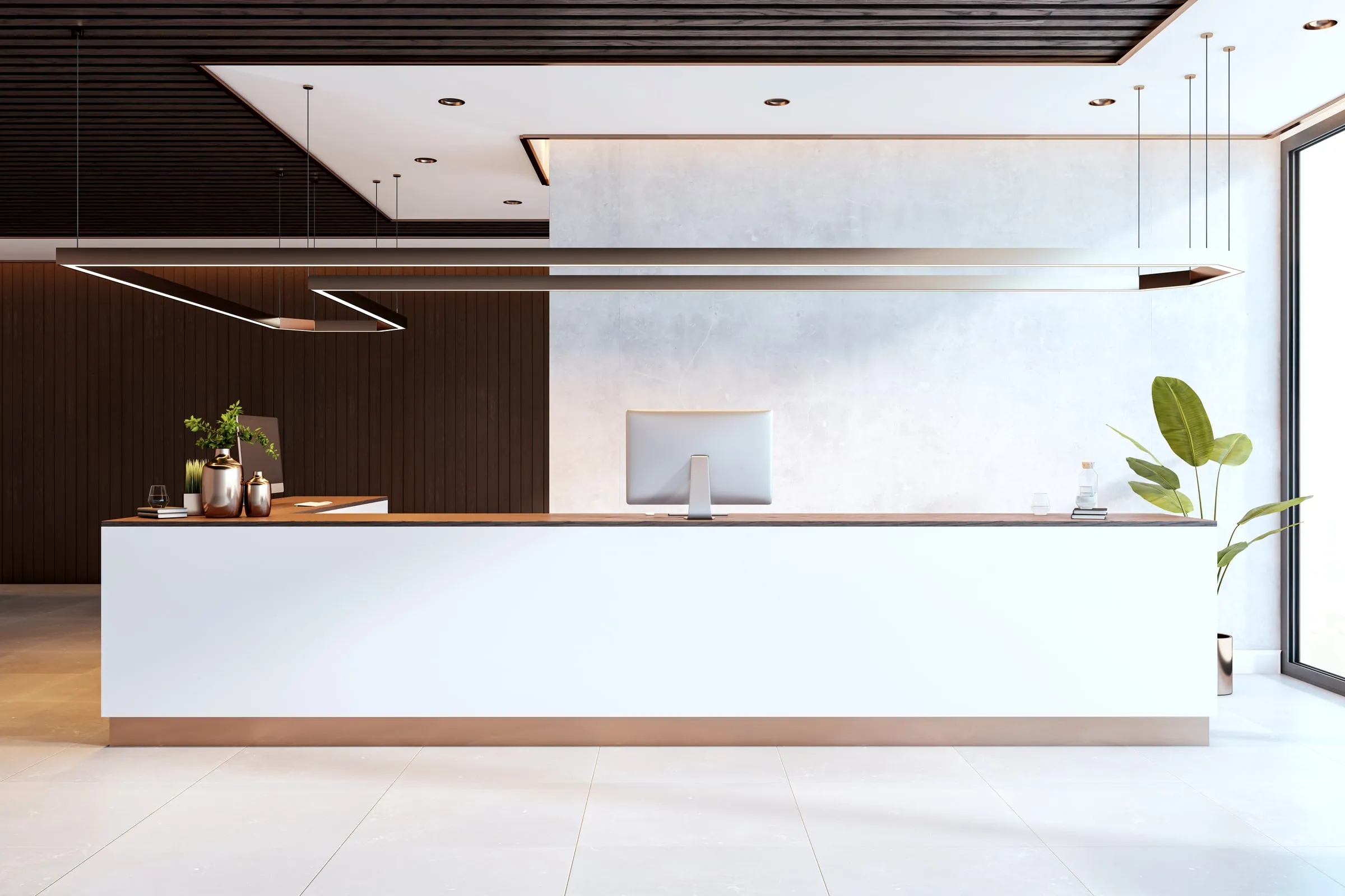 Modern reception desk in a law office lobby with dark wood paneling, pendant lighting and a computer monitor facing an empty visitor area
