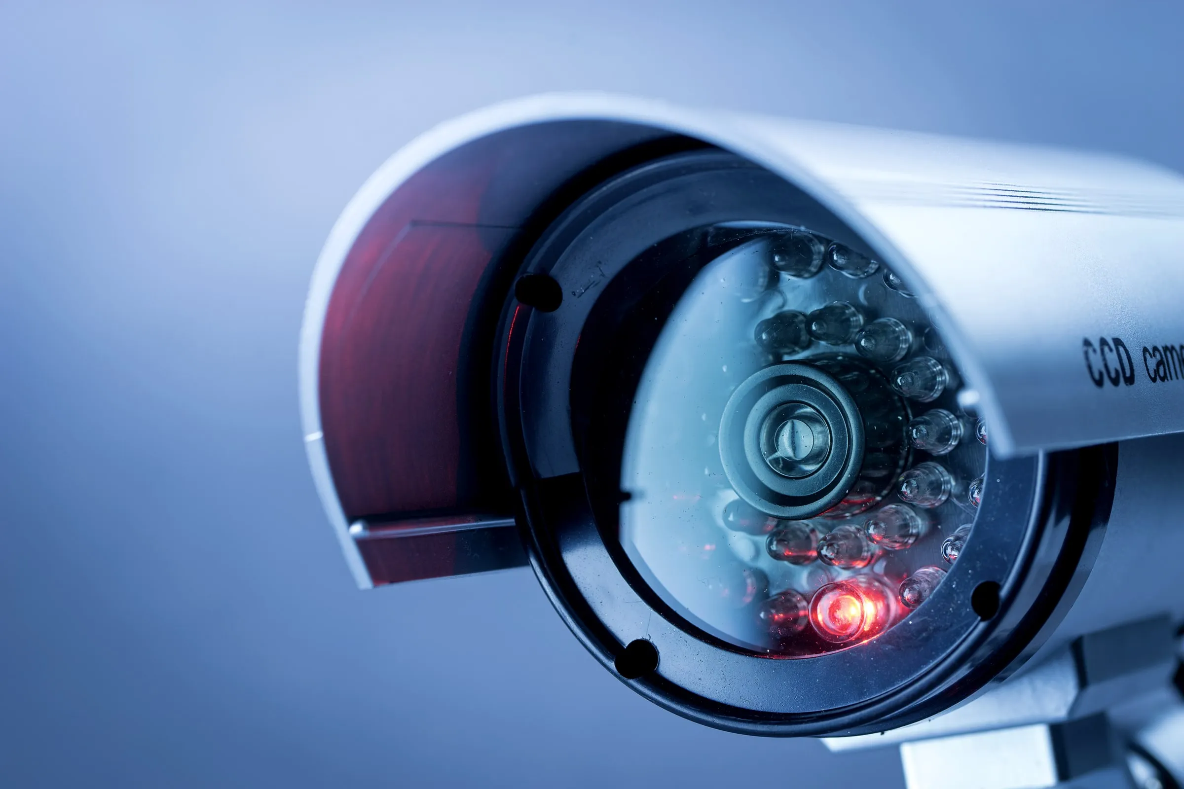 Close-up of an infrared security camera lens mounted outdoors with its ring of night-vision LEDs lit