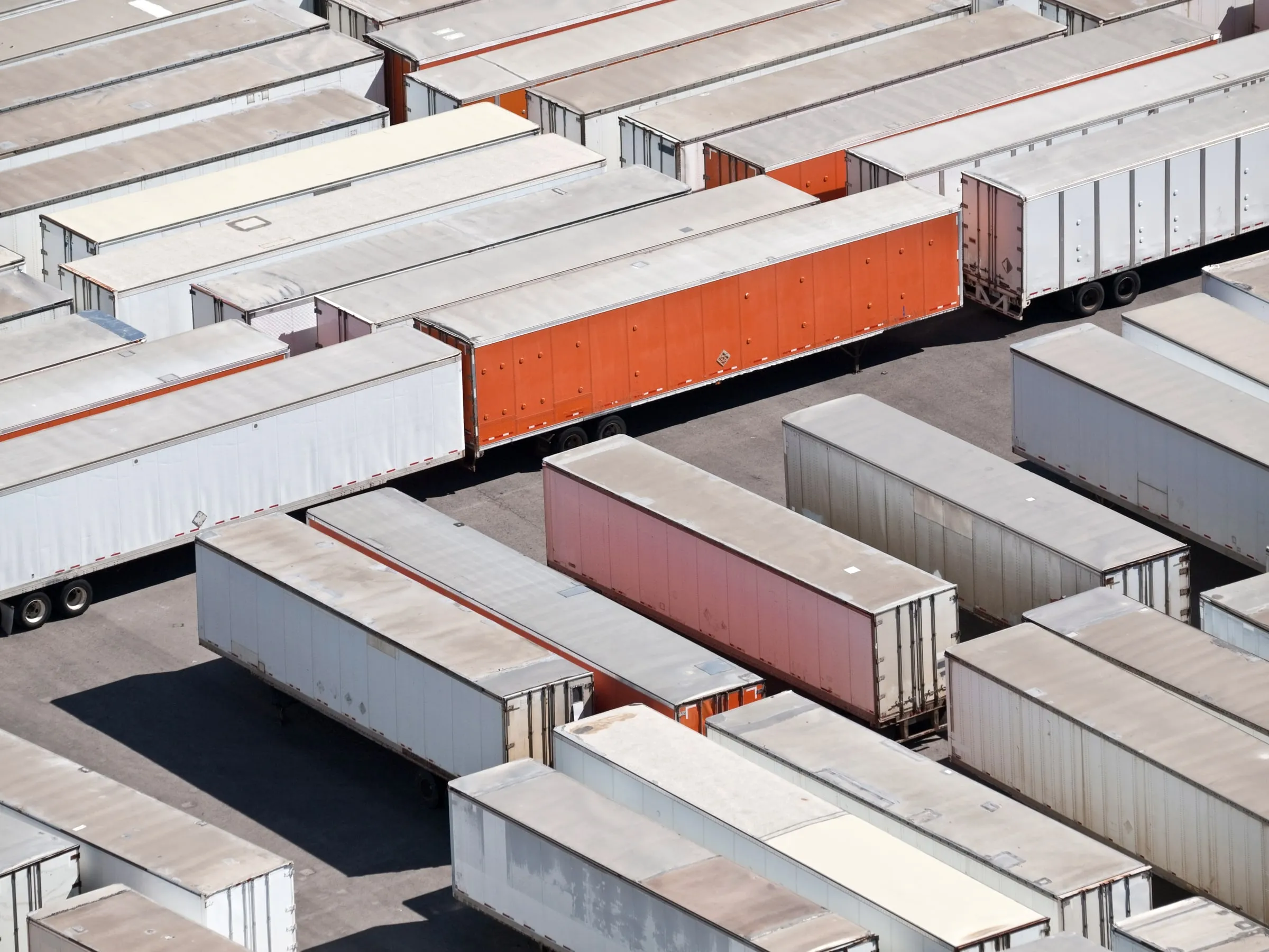 Aerial view of a truck terminal yard packed with dozens of parked trailers in tight rows