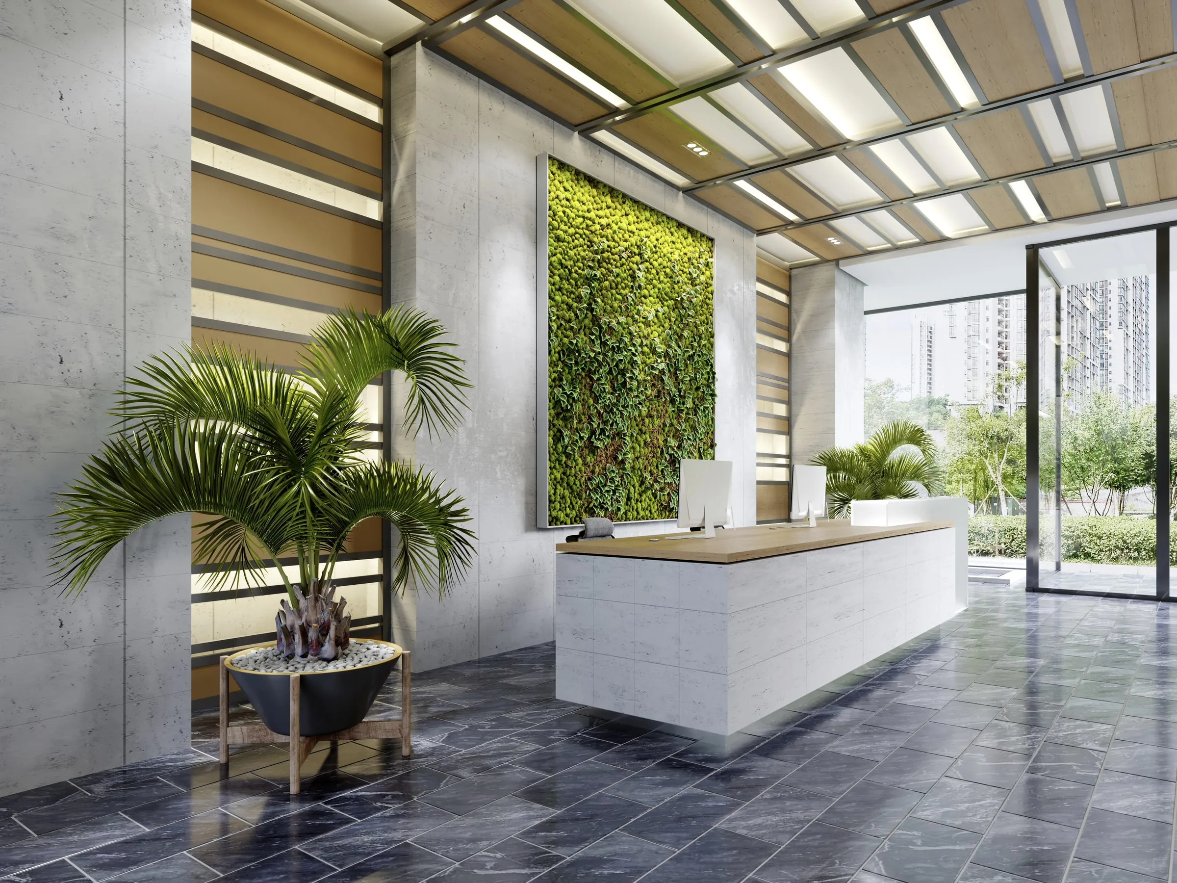 Bright apartment lobby with a living green wall behind a long white stone reception desk, palm plants and floor-to-ceiling glass looking out to trees and towers