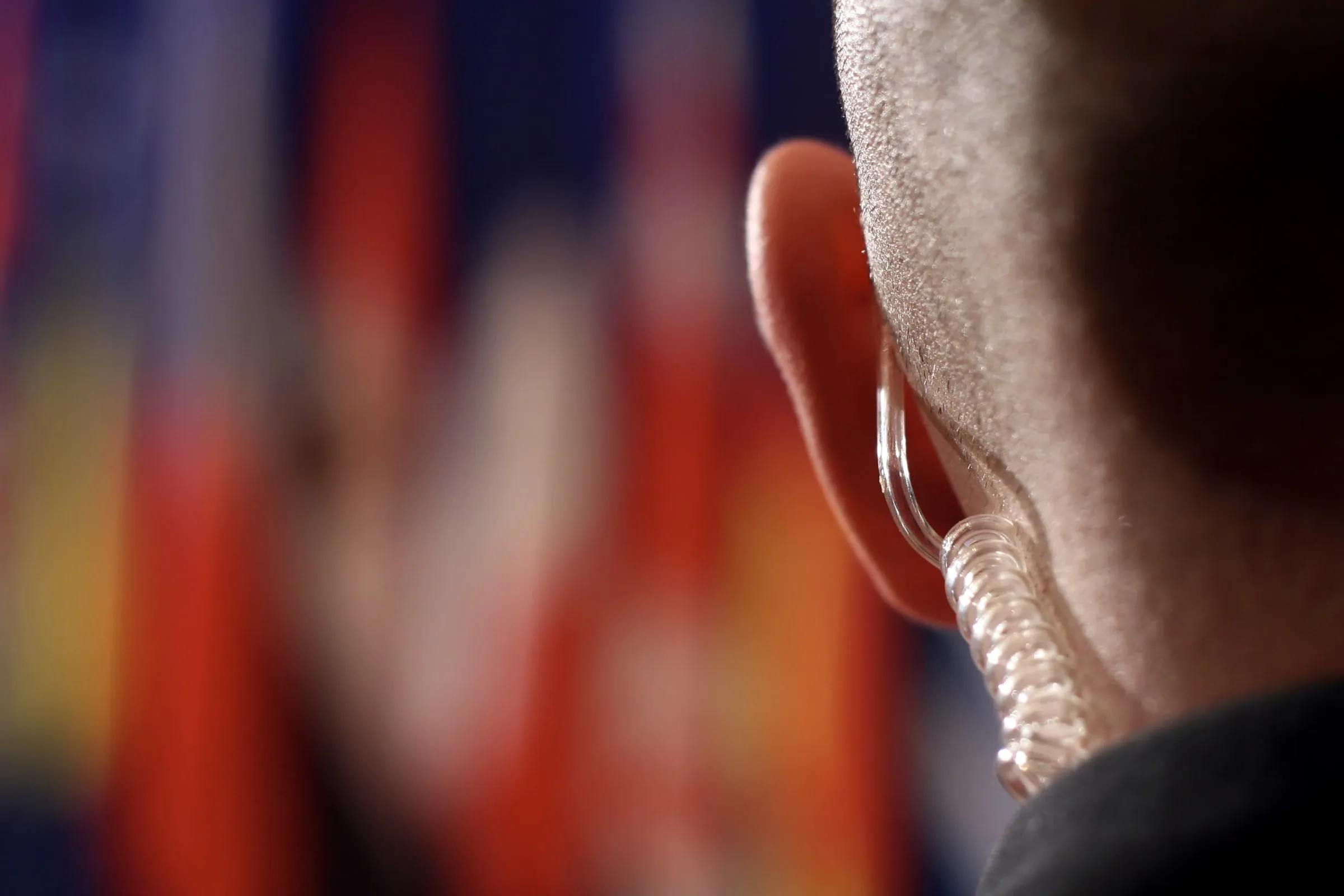 Close view of a security officer's ear with a coiled earpiece