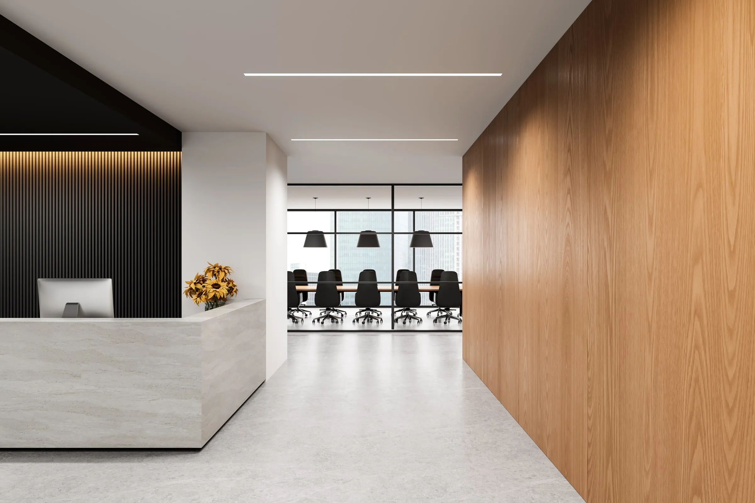Unstaffed reception desk with a wood-panelled wall in a modern office lobby, a glass conference room visible beyond